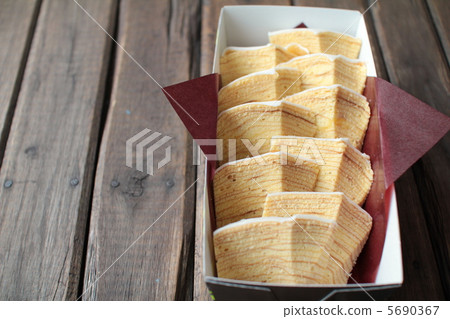 將年輪蛋糕切成小塊放入盒中 - 烘焙食品 5690367