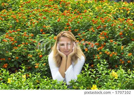 Young woman sitting in flowers Young woman sitting in flowers 5707102