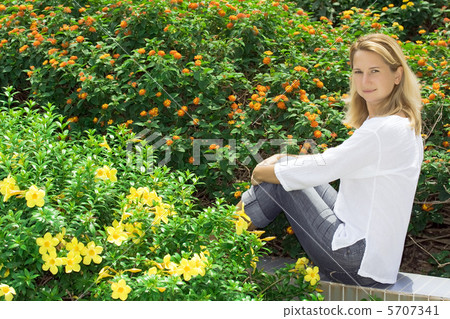 Young woman sitting in flowers Young woman sitting in flowers 5707341