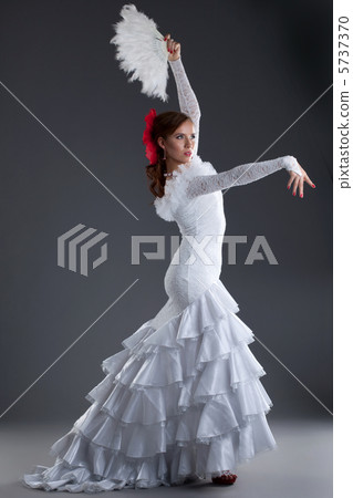 Young woman in white dress performing flamenco 5737370