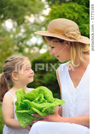 Young mother and daughter with lettuce Young mother and daughter with lettuce 5773169