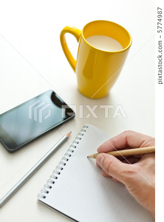 Writing notes or planning a schedule on blank spiral notebook 5774987