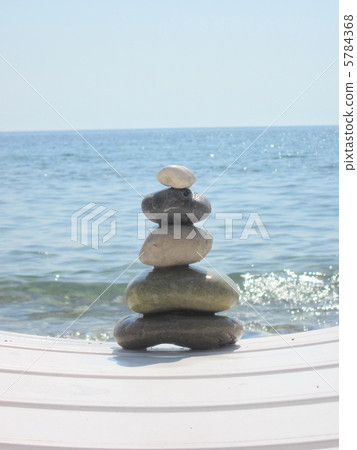 The stack of pebble stones in zen concept  on chaise longues 5784368
