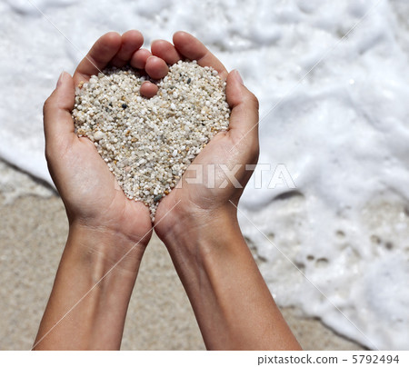Mellow heart shaping female hands above beach Mellow heart shaping female hands above beach 5792494
