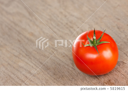 Red tomato on a brown table Red tomato on a brown table 5819615