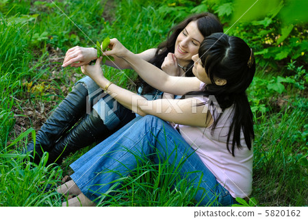 Two sisters sitting on the grass 5820162