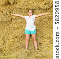 Girl on the background of the large stack of hay 5820958