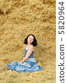 Young attractive woman on the background of the large stack of h 5820964