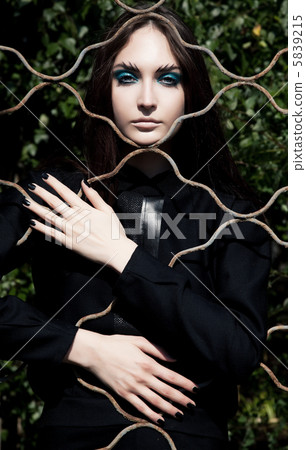 Emotions. Pretty woman posing in cage outdoors 5839215