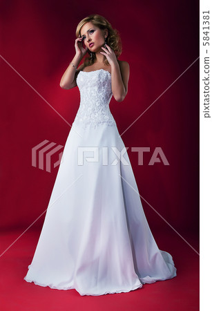 Beautiful fiancee blonde in white nuptial dress posing 5841381