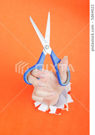 Hand with scissors from paper hole 5864022
