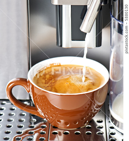 Coffee maker pouring fresh milk coffee in a cup 5880130