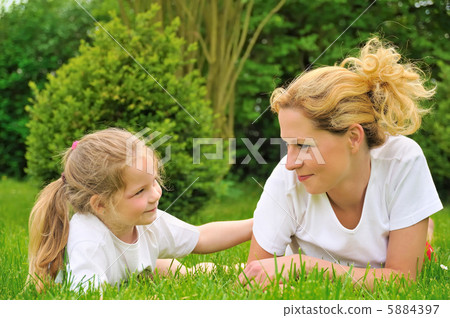 Young mother and daughter laying on the grass Young mother and daughter laying on the grass 5884397