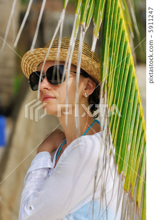 Woman in sunglasses near palm tree 5911247
