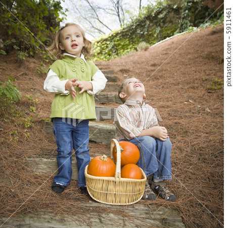 Brother and Sister Children on Wood Steps with Pumpkins Singing 5911461
