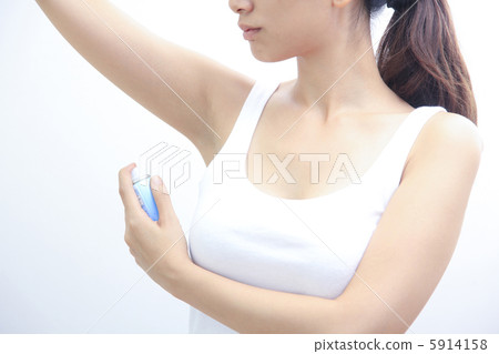 A woman spraying a deodorant antiperspirant 5914158