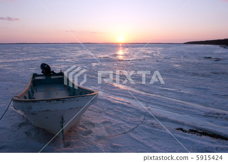Winter lotus lake frozen lake surface, small boat and sunset 5915424