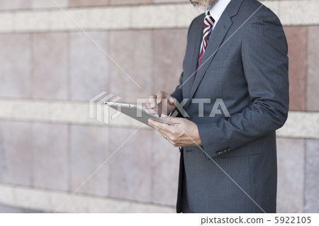 A businessman operating a tablet PC A businessman operating a tablet PC 5922105