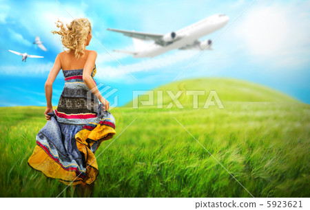 Woman running across field with idyllic landscape. Airplane and 5923621