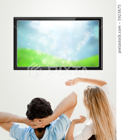 Young couple watching tv. Photo from behind. Lots of copyspace Young couple watching tv. Photo from behind. Lots of copyspace 5923675