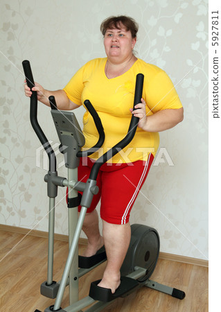 overweight woman exercising on trainer 5927811