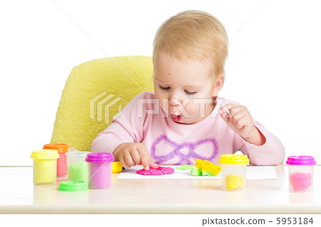 Little kid sitting at table playing with colorful clay Little kid sitting at table playing with colorful clay 5953184