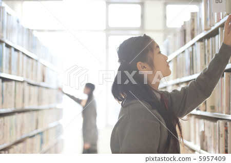 Junior high school students who choose books in the library 5957409
