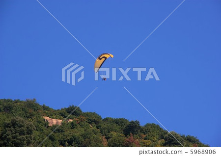 A sunny blue sky where a paraglitter flees 5968906