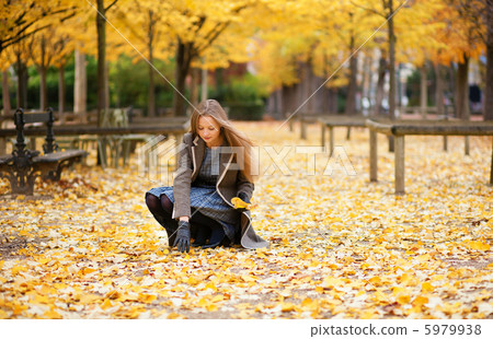 Girl gathering autumn leaves Girl gathering autumn leaves 5979938