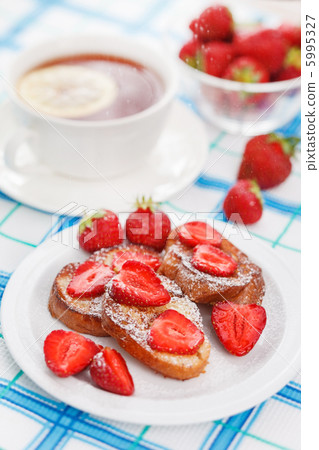 French toasts with powdered sugar and a strawberry 5995327