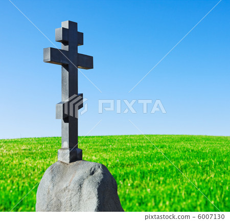 stone cross on a pedestal stands in a field stone cross on a pedestal stands in a field 6007130