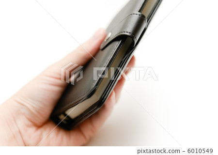 A hand holding a black notebook A hand holding a black notebook 6010549