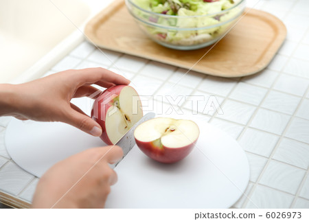 The hands cutting the apple and the salad 6026973