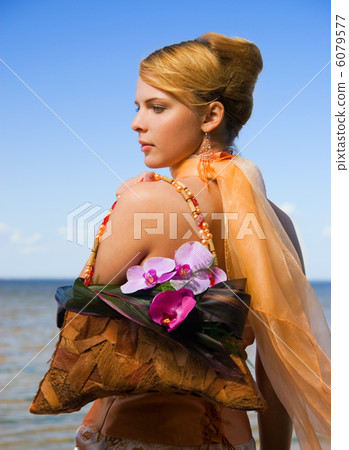 Redhead girl on the beach with floral handbag 6079577