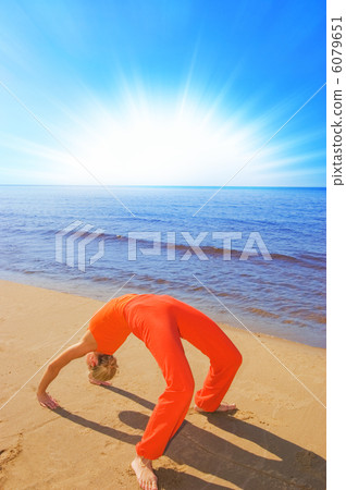 Blond girl shows some yoga moves on the beach 6079651