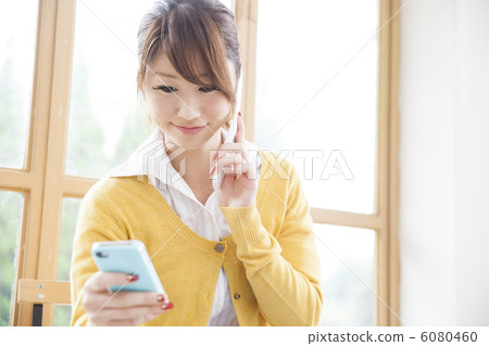 一個女人在看著平板電腦的同時打電話 6080460