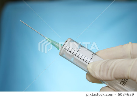 syringe in hand on blue 6084689