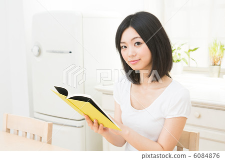 讀一本書的婦女在廚房裡 讀一本書的婦女在廚房裡 6084876