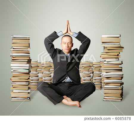 businessman in lotus pose with many books near businessman in lotus pose with many books near 6085878