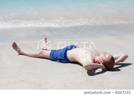 Man relaxing on beach 6087291
