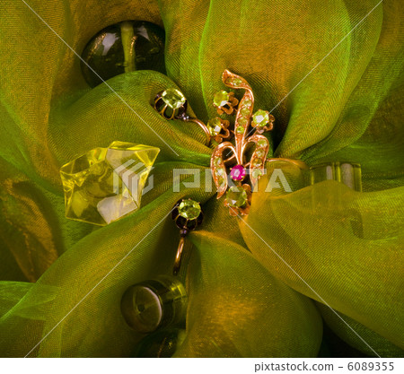 Golden jewelry on green background Golden jewelry on green background 6089355