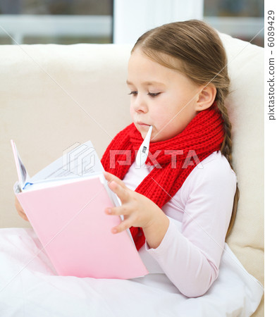 Ill little girl with thermometer is reading book 6089429
