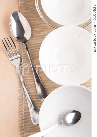 white bowls and silverware on napkin and wood 6100628
