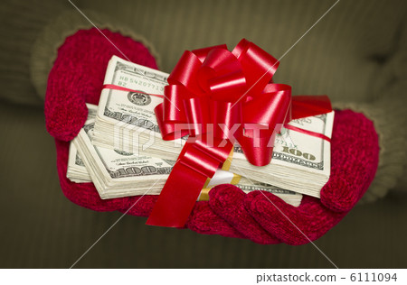 Woman Wearing Mittens Holding Stacks of Money with Red Ribbon Woman Wearing Mittens Holding Stacks of Money with Red Ribbon 6111094