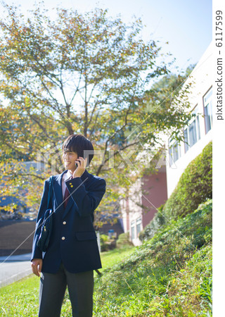 Male high school student speaking on a smartphone 6117599