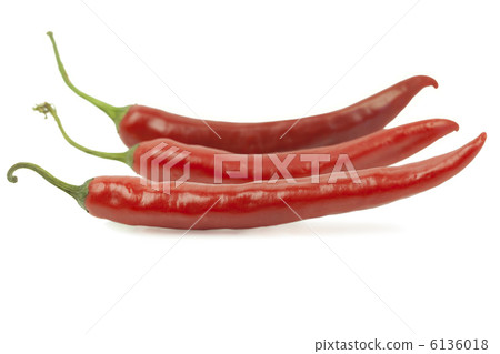 Three red peppers on a row on a white background 6136018