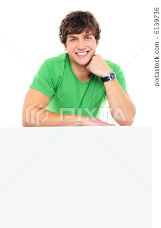 Handsome smiling man lean on the white billboard 6139736