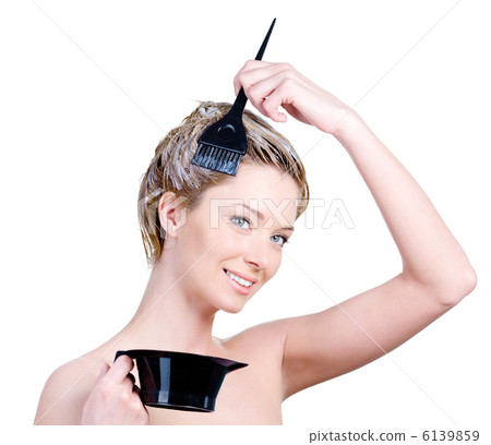 Woman with brush and capacity for hair-dye coloring her hair Woman with brush and capacity for hair-dye coloring her hair 6139859