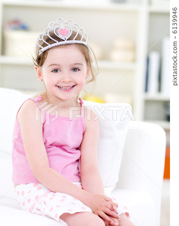 Little happy girl with crown at home 6139946
