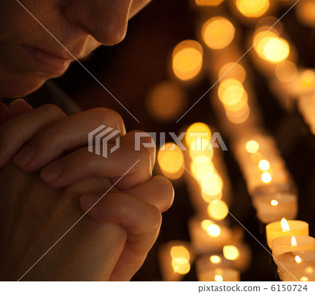 Woman praying in church cropped part of face and hands closeup p 6150724